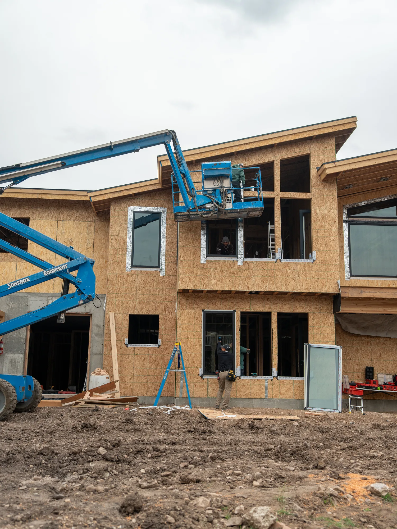 UOME crew installing upper-level windows from a boom lift