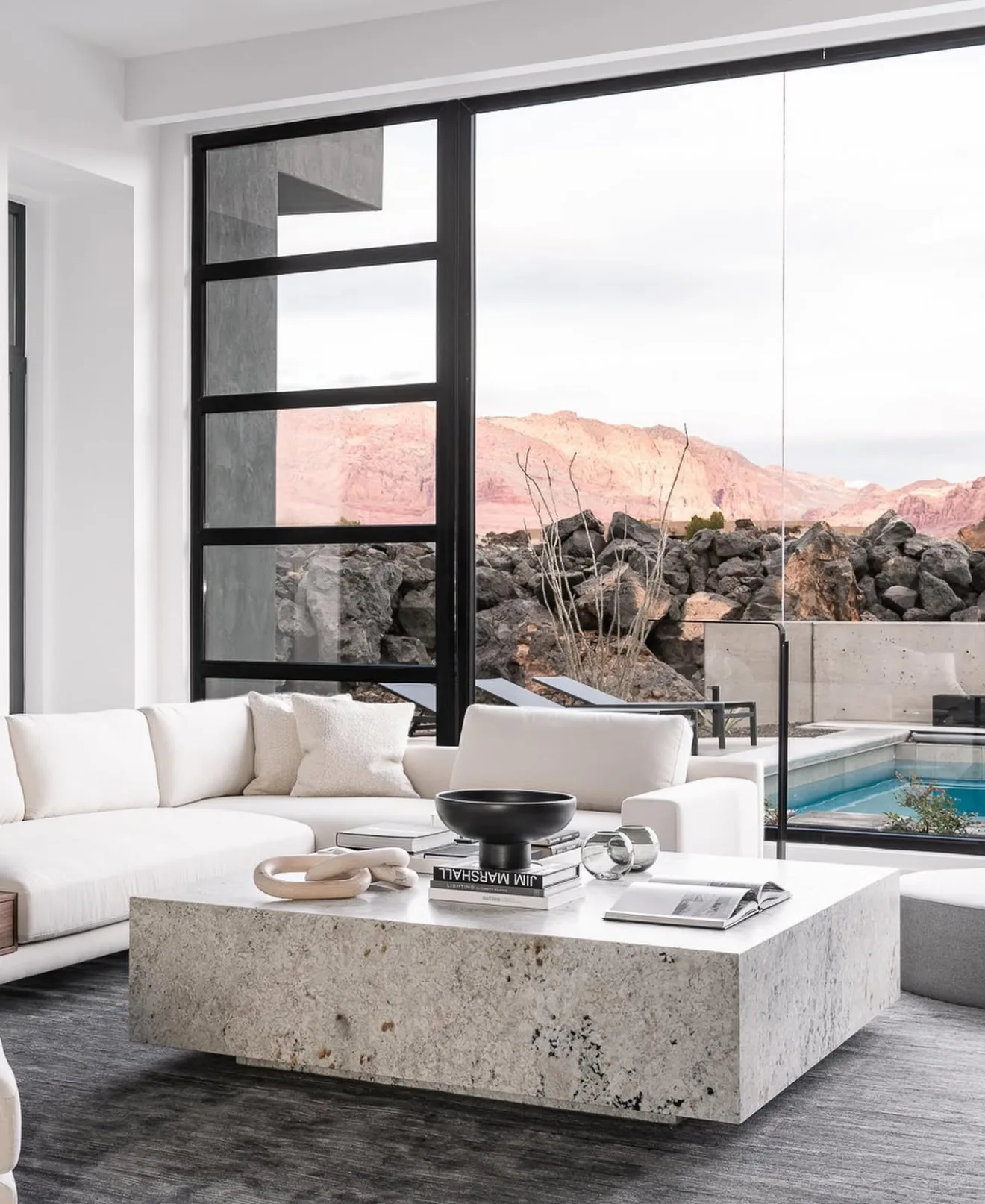Floor-to-ceiling architectural glass framing a desert view
