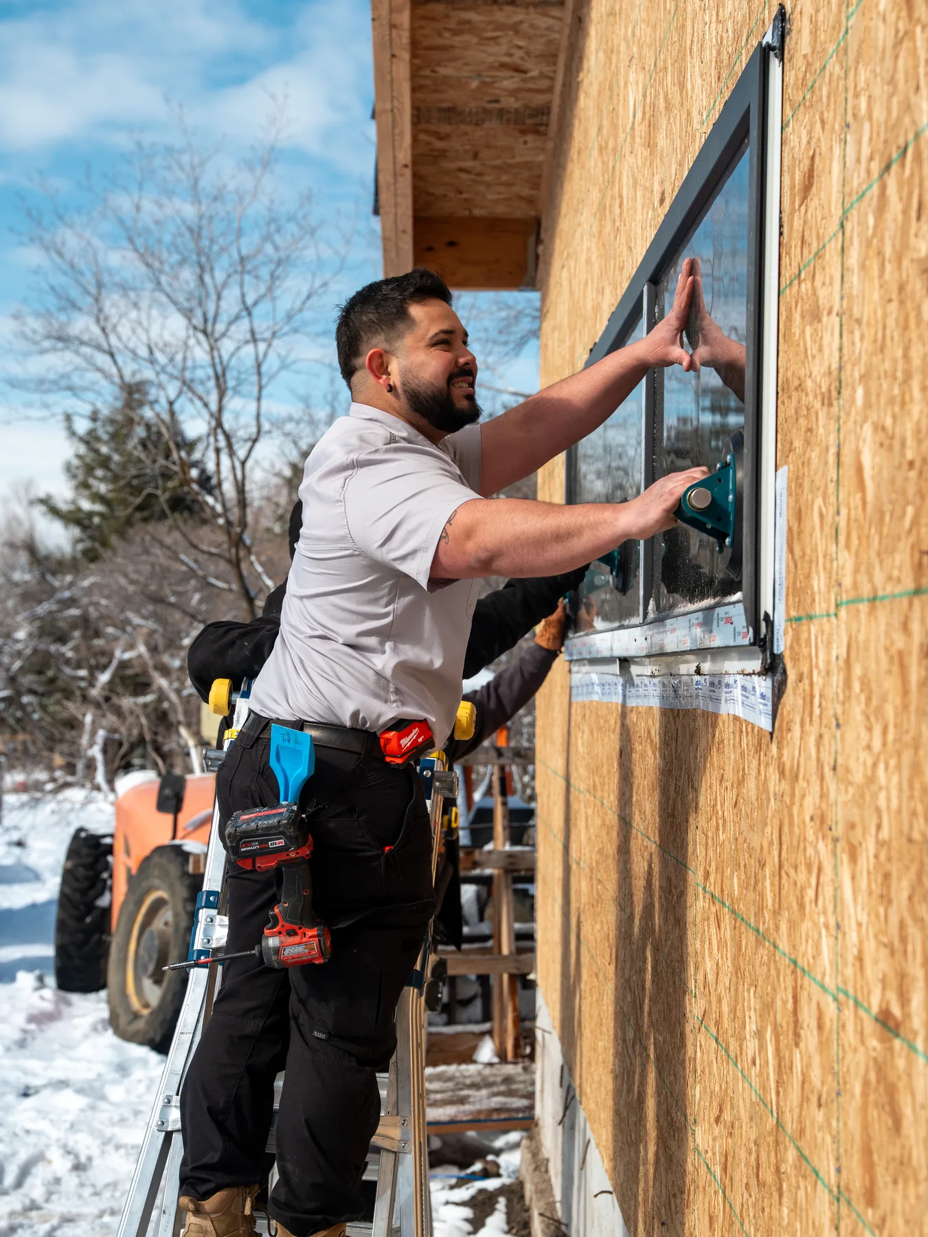 UOME installer aligning a black window frame in a prepared opening